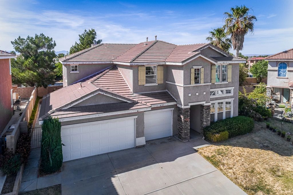 Two-story suburban house with a double garage and beige exterior.