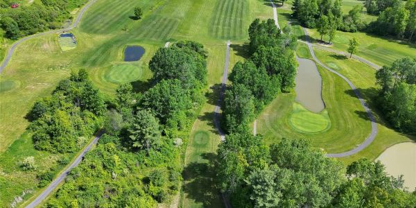 Aerial view of a golf course with greens and ponds.