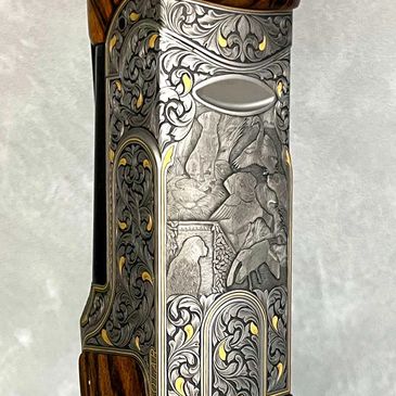 Intricately engraved gun receiver with gold inlay and wooden stock.