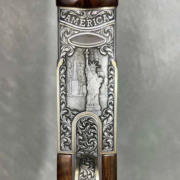 Engraved gun part featuring the Statue of Liberty and New York landmarks.