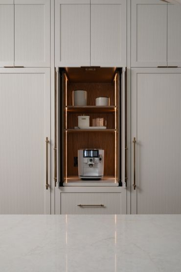 Built-in coffee station with modern espresso machine and elegant lighting.