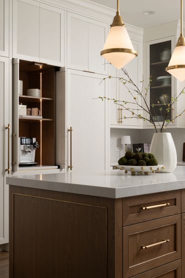 Modern kitchen with built-in coffee machine and elegant island decor.