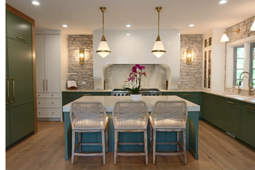 Modern kitchen with green cabinets, marble island, and woven bar stools.
