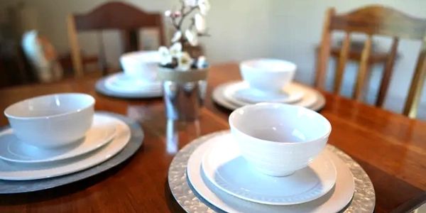 A table with plates and bowls on the hotel table.