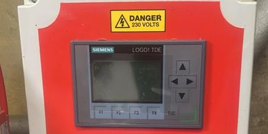 Siemens LOGO! TDE control panel with 230 volts danger sign.