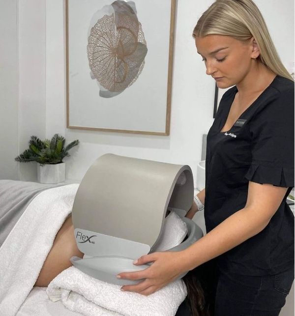 A clinician putting the Dermalux LED phototherapy device on a clients face