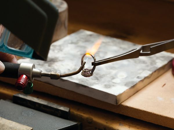 pliers holding a ring soldered together. 