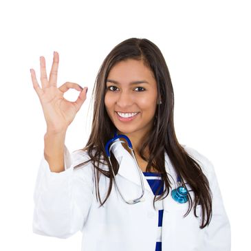 Smiling female doctor showing OK gesture with stethoscope around her neck.