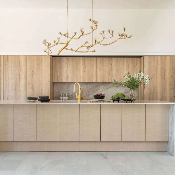 Minimalist kitchen with wooden cabinets and a unique branch-like chandelier.