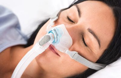 woman sleeping weating nasal cpap mask
