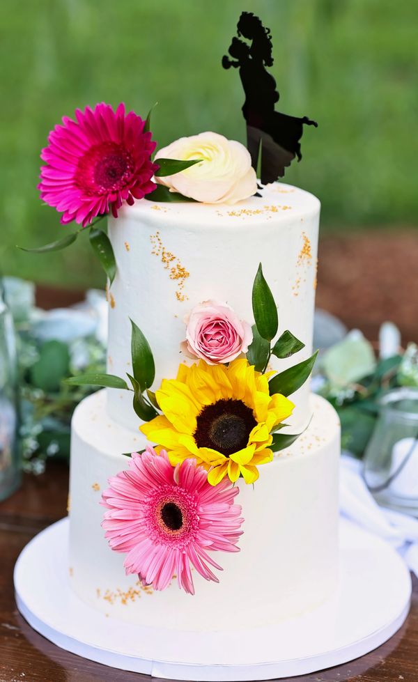 2 tiered wedding cake with real sunflowers. Photo provided courtesy of Capturedbyceleste.com