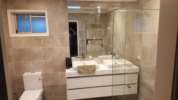 perfect tiling on elite bathroom with open glass shower and fine finishing