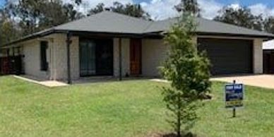 Single-story modern house with a front lawn and 'For Sale' sign.