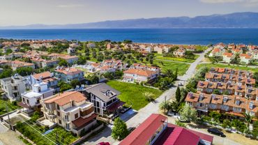 Aerial view of a coastal residential neighborhood with houses near the sea.