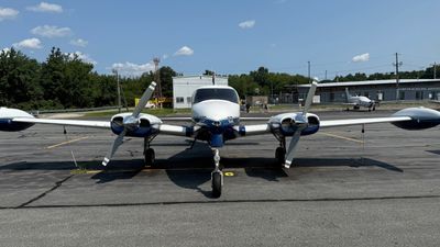 Twin-engine propeller airplane parked on runway.