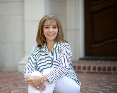 Smiling woman with shoulder-length hair wearing a striped shirt.