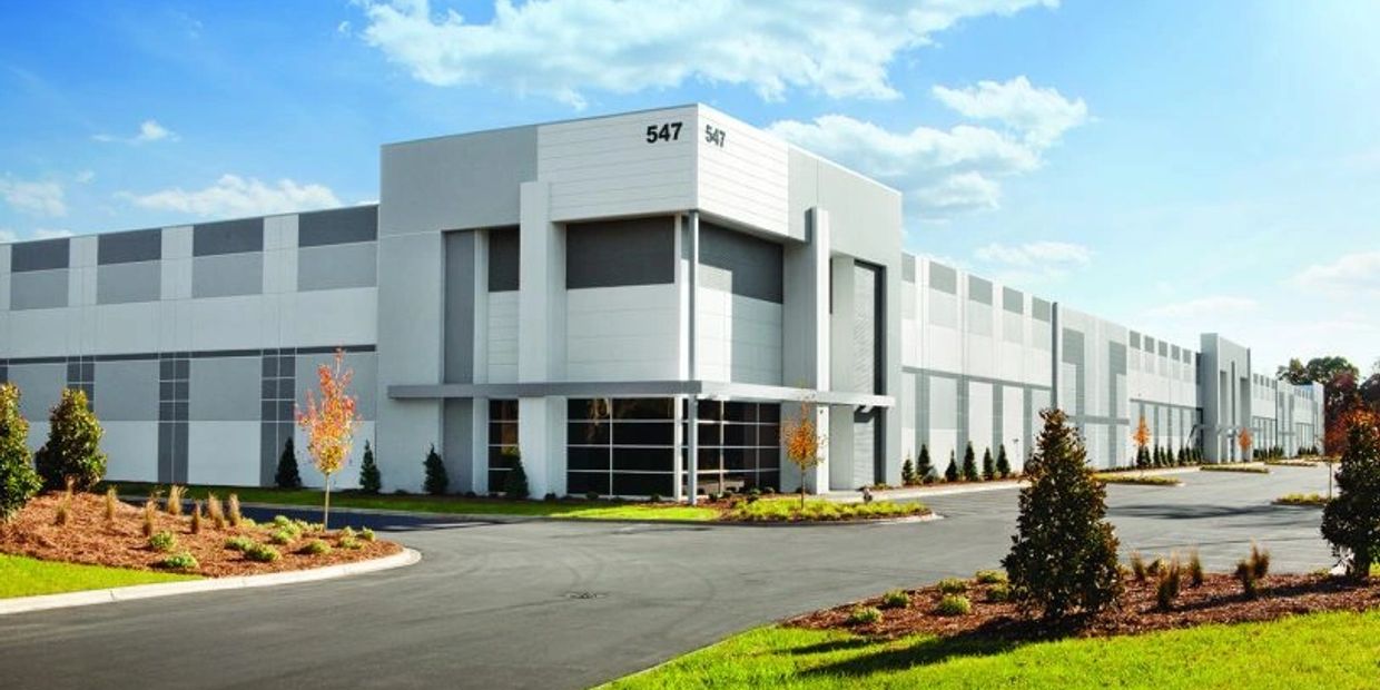 Modern industrial warehouse building with clean landscaping.