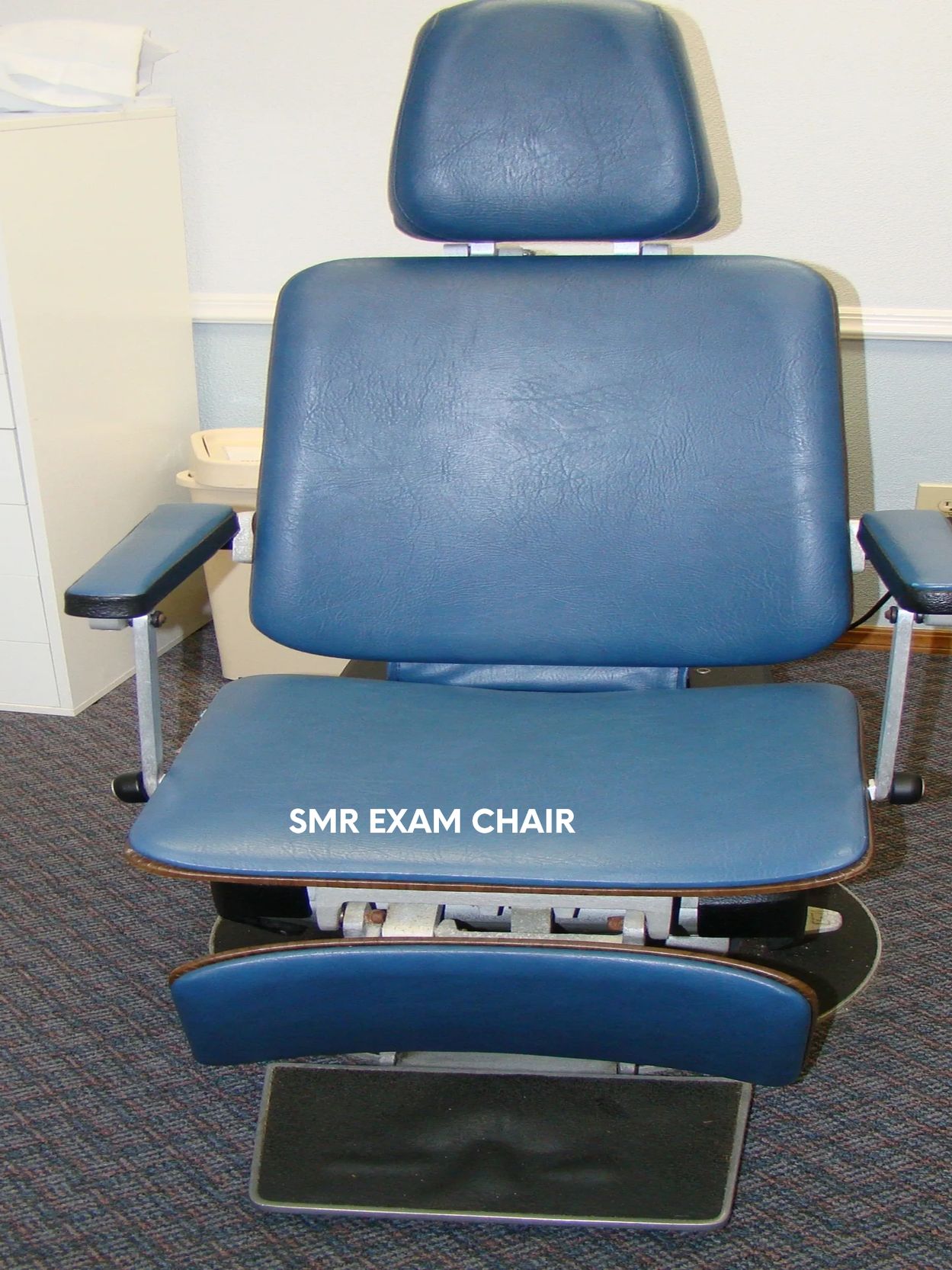Blue SMR exam chair in a clinical setting.