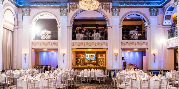 Elegant banquet hall with round tables and ornate architecture.