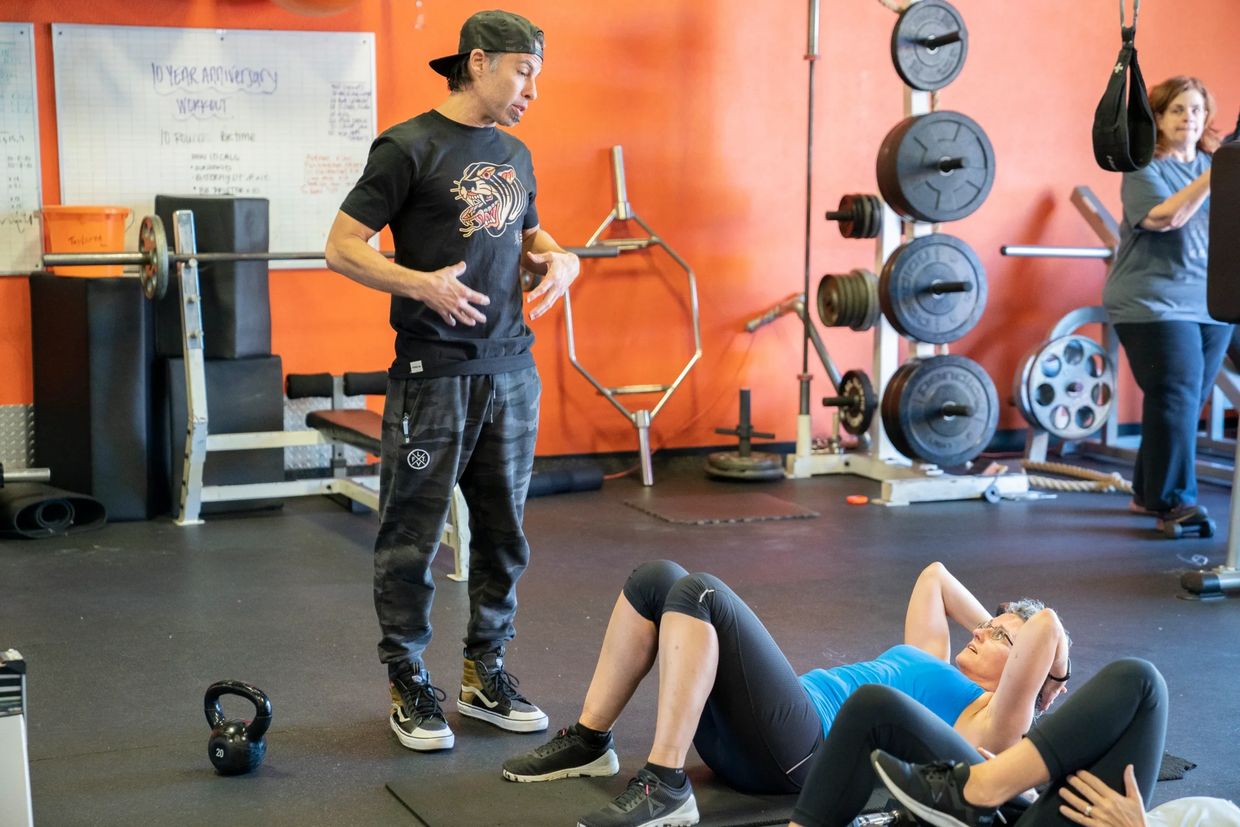 personal trainer showing a client an ab exersize