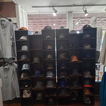Display of various caps on shelves in a store.