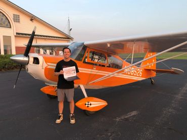 Excited client next to aerobatic airplane after completing Upset Prevention and Recovery training