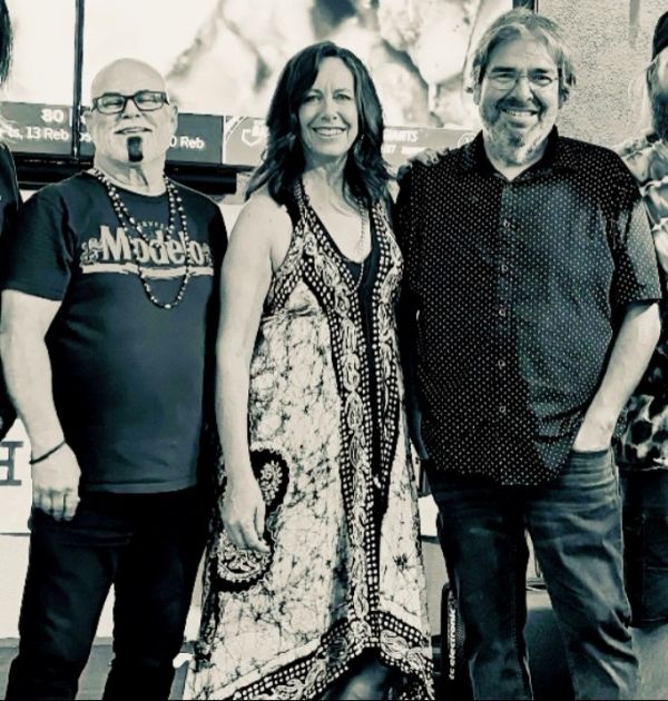 Group of three smiling adults posing together.