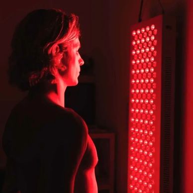 Man using a red light therapy panel for wellness.