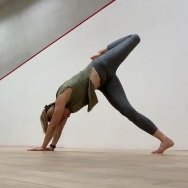 Woman practicing yoga with a raised leg in a studio.