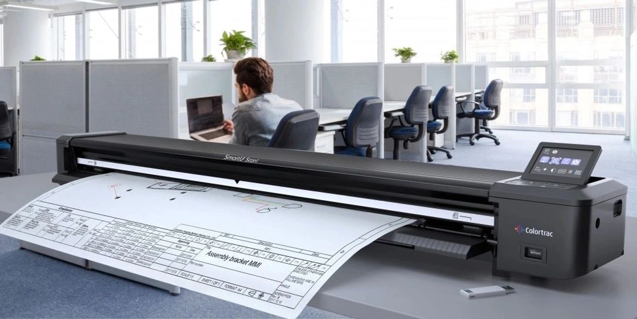 A large-format scanner scanning a technical drawing in a modern office.