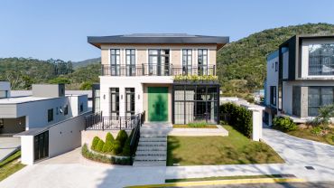 Casa moderna com jardim e porta verde.