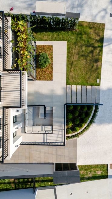 Vista aérea de jardim moderno e área de estar externa.