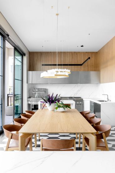 Sala de jantar moderna com mesa de madeira e cadeiras marrom.