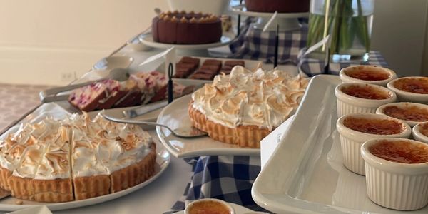 A dessert table with meringue pies, crème brûlée, and other sweets.