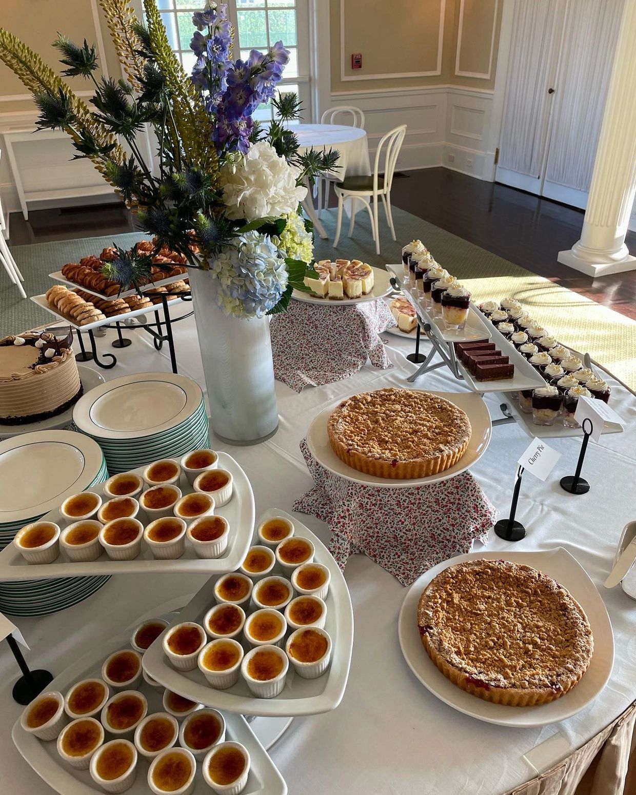 Elegant dessert table with various sweet treats and a floral centerpiece.