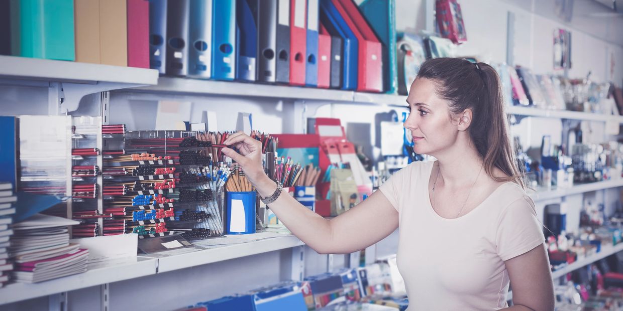Woman shopping for colored pencils and stationery in a store.