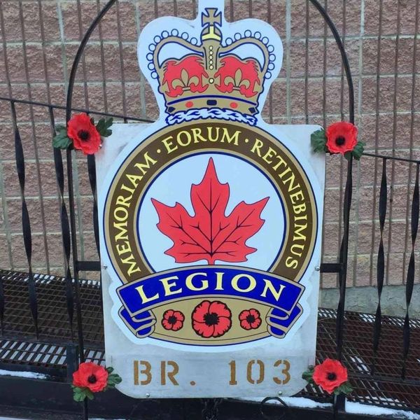 Emblem of a Legion branch with poppies and a crown.