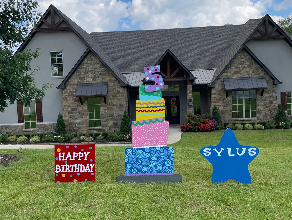 Outdoor birthday decorations with a colorful cake and star.