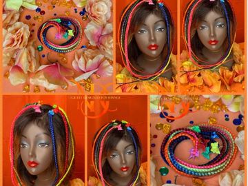 Colorful braided hair extensions displayed on mannequins and in a heart shape.