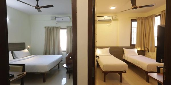 Two adjacent hotel rooms with modern decor and air conditioning.