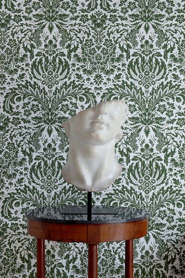 Patterned wallpaper with antique table and sculpture. Paolo Moschino Ltd. 