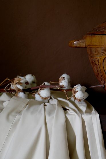 Cotton buds on cotton sheet against brown background