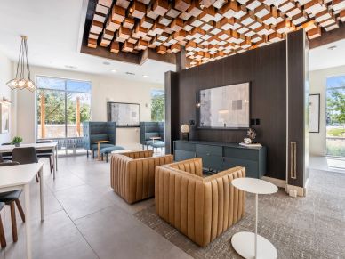 Modern lounge area with stylish furniture and wooden ceiling decor.