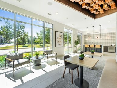 Bright modern lounge with large windows and seating.