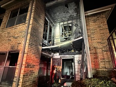 Burnt-out building with fire damage at night.