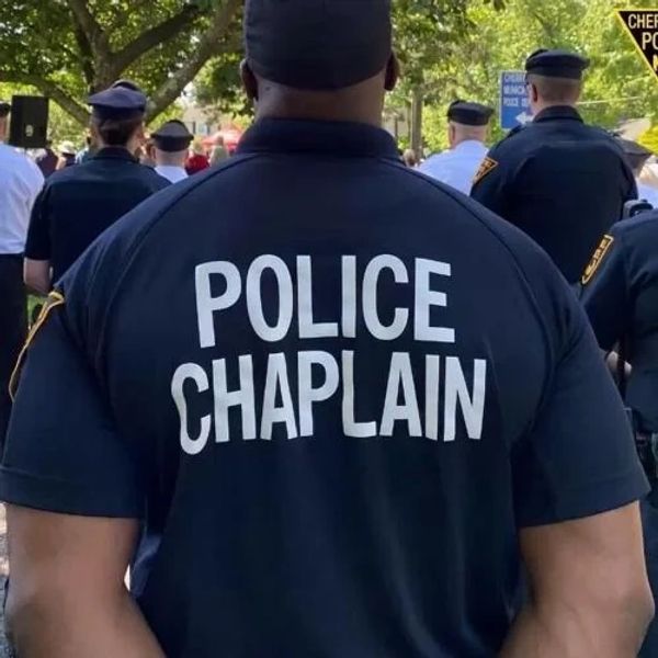 Police chaplain in uniform at an outdoor event.