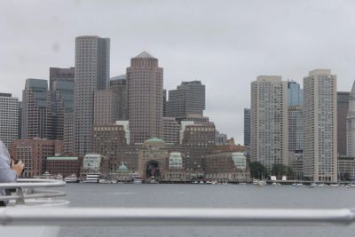 View of a city skyline with tall buildings by the water on a cloudy day.