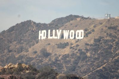 The iconic Hollywood sign on a hill under a clear sky.