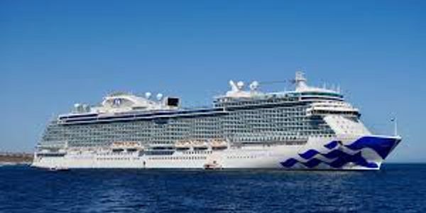 Large white cruise ship on blue ocean.