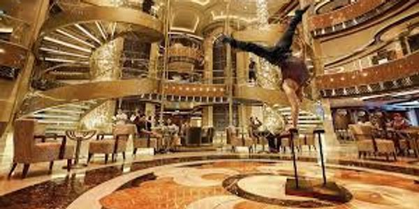 Acrobat performing handstand in luxurious lobby.